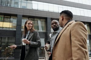 Courtier immobilier Gatineau discutant avec clients potentiels devant immeuble moderne. Valorisation immobilière et vente propriétés par agent immobilier expérimenté Outaouais.