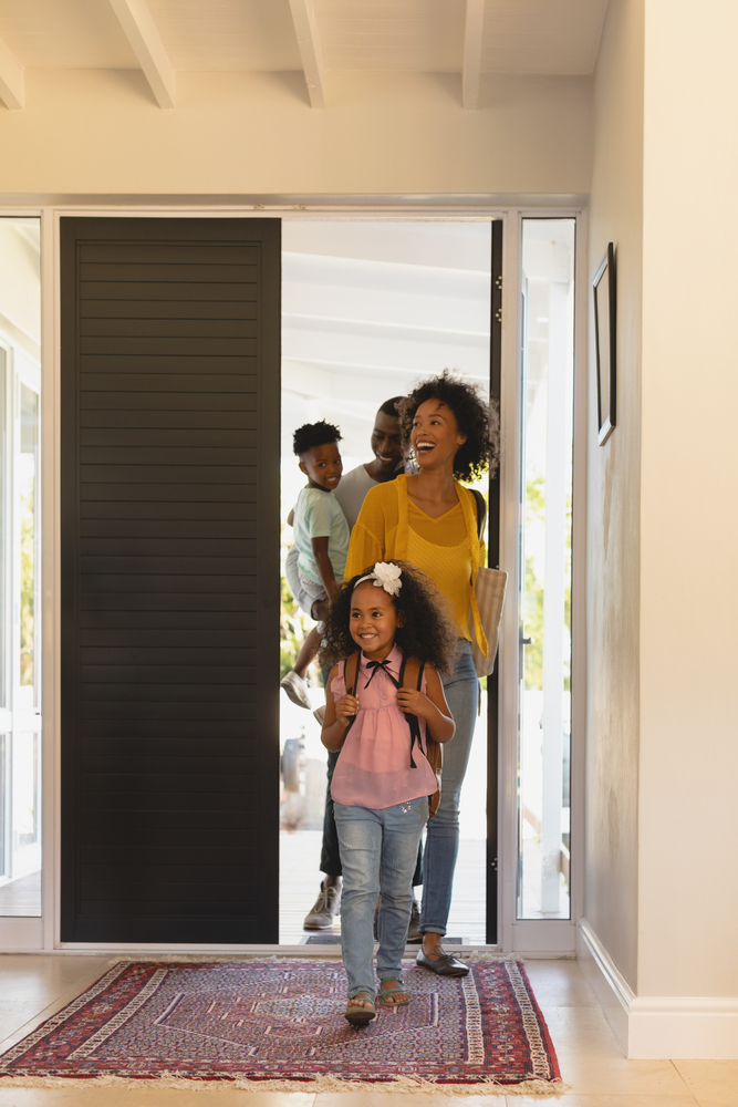 Famille rayonnante dans entrée accueillante de maison achetée avec agent immobilier Gatineau. Valorisation immobilière réussie pour cette propriété à vendre.