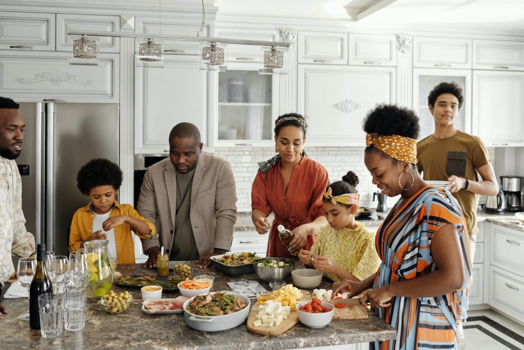 Famille préparant et partageant un repas convivial dans une cuisine moderne et chaleureuse. Scène représentative d'un foyer accueillant, valorisant l'achat d'une maison à vendre par un courtier immobilier Gatineau.